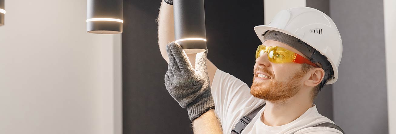 Electrician installing commercial light fittings